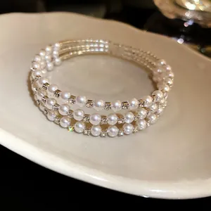 Detail view of a luxury multilayer bracelet featuring elegant white pearls and rhinestones.