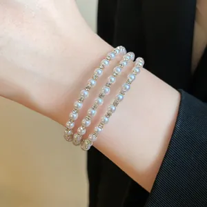 Detailed view of an elegant multi-layer pearl bracelet with sparkling rhinestone accents.