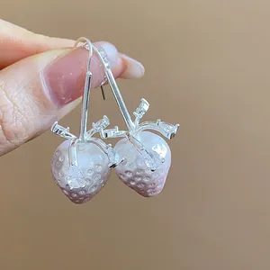 Detailed macro view of strawberry drop earrings with shiny water drop zircon accents
