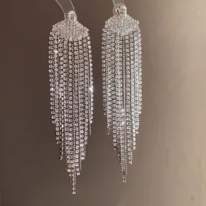 Boucles d'oreilles élégantes à pompons argentés avec design en strass
