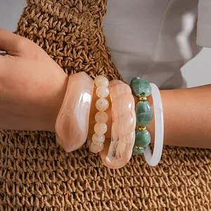 Close-up detail of stacked acrylic bangles with marble effect and beaded textures