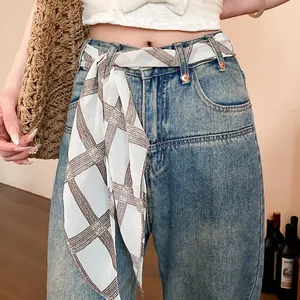 Close-up of retro plaid chiffon scarf used as a stylish belt accessory on denim jeans