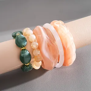 Set of chunky acrylic resin bracelets with green marbled beads and peach bangles