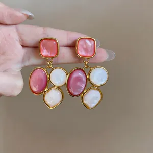Close-up detail of vintage court style geometric resin drop earrings in pink and white colors