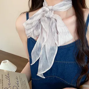 Detailed close-up of retro pleated chiffon scarf with purple striped pattern on model.