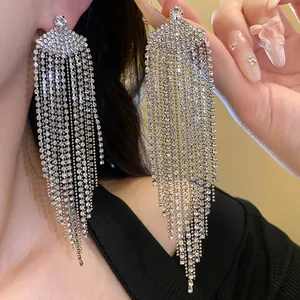 Gros plan montrant les détails des strass des boucles d'oreilles à pompons en éventail