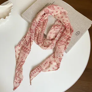 Detail view of a vintage paisley print chiffon scarf in elegant pink and red tones