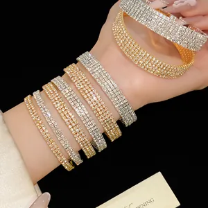Vista detallada de varios brazaletes de diamantes de imitación en oro y plata.