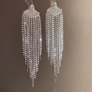 Détail macro exquis de boucles d'oreilles élégantes à pompons en strass avec tiges en argent