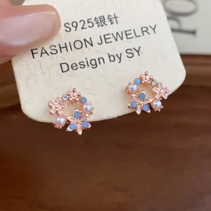 Vista dettagliata di orecchini a ghirlanda con fiori, perle e perno in argento S925.