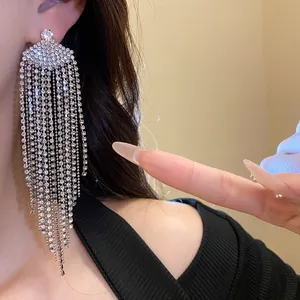 Détail de gros plan des boucles d'oreilles à pampilles en éventail avec strass brillants