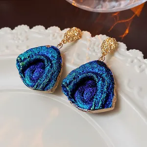 Detailed close-up of vintage French resin earrings with blue-purple iridescent texture.