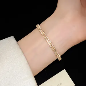 Primer plano de una elegante pulsera dorada de doble capa con brillantes diamantes de imitación