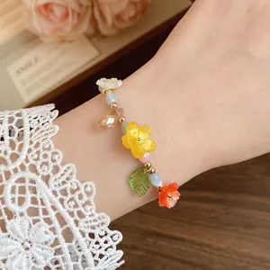 Colorful candy-colored beaded flower bracelet on a wrist with lace