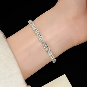Vista detallada de un brazalete abierto plateado de varias capas con pedrería brillante.