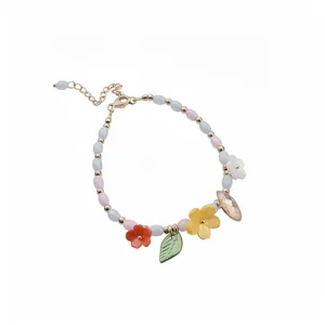 Pastel beaded bracelet with colorful enamel flower charms and leaf pendant