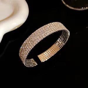Primer plano exquisito de un brazalete de diamantes de imitación multicapa con diseño abierto