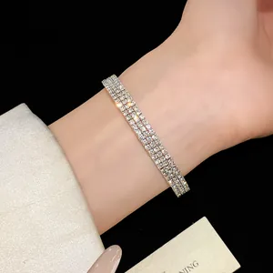 Primer plano de una elegante pulsera plateada multicapa con pedrería.