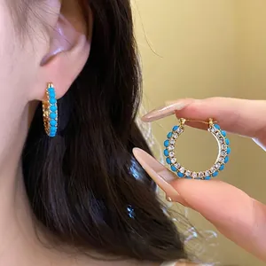 Vintage gold hoop earrings featuring turquoise beads and shimmering cubic zirconia stones
