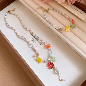 Close-up of candy-colored beaded necklace and bracelet with enamel flower charms