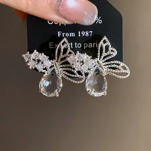 Eleganti orecchini a farfalla in argento con zirconi lucenti su carta da esposizione