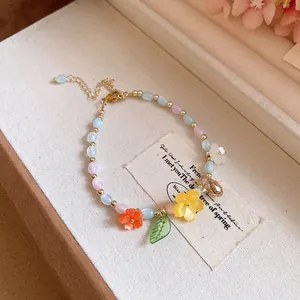 Detail of colorful beaded bracelet featuring delicate oil-dripping flower and leaf charms