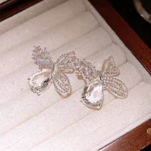 Eleganti orecchini a perno a farfalla color argento con ali traforate e zirconi.