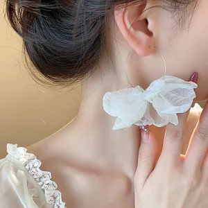 Close-up detail of sweet white lace flower hoop earrings for elegant resort style