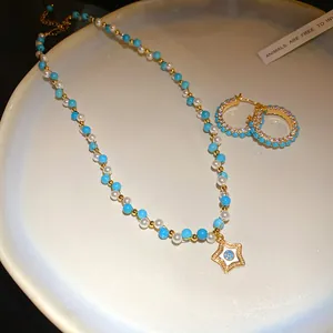 Close-up detail of vintage style beaded pearl necklace and star charm earrings set