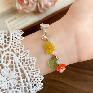 Close-up of sweet candy-colored flower beaded bracelet with leaf charm on wrist