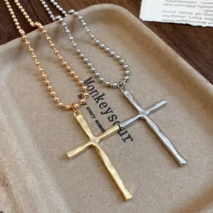 Close-up detail of vintage metal cross pendant necklaces in gold and silver finishes