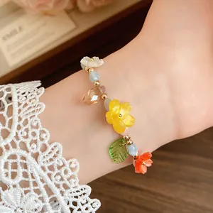 Close-up detail of a sweet candy-colored flower and leaf beaded bracelet worn on wrist