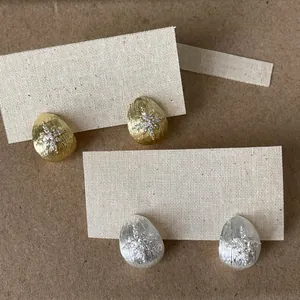 Detailed view of 18k gold plated teardrop stud earrings with starburst zircon inlay