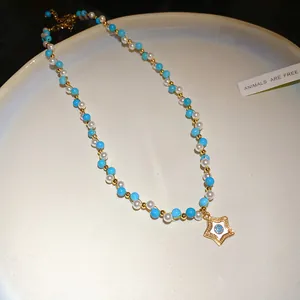 Detailed view of a vintage beaded necklace with pearls and golden evil eye star pendant