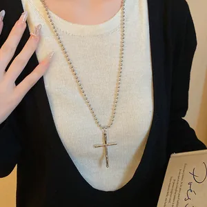Detailed view of vintage silver cross pendant necklace with textured molten finish
