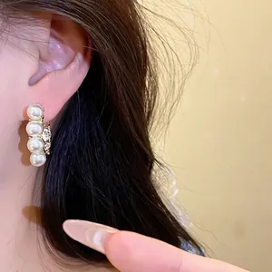 Elegante französische Vintage-Ohrringe mit Perlen und Strass am Ohr getragen
