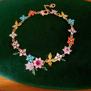 Detailed close-up of 18k gold-plated flower bracelet with colorful zircon and pearls.