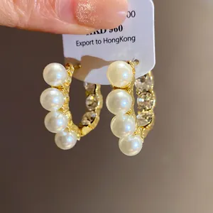 Detailansicht französischer Vintage Gold-Creolen mit weißen Perlen und Strass