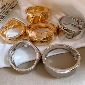 Detailed view of chunky glossy metallic bangles in gold and silver finishes