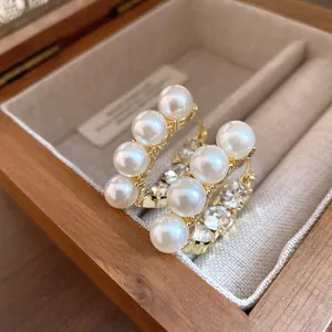 Detailansicht luxuriöser goldener Vintage-Ohrringe mit weißen Perlen und Kristallen