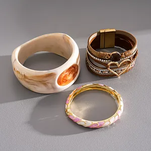Dettaglio del bracciale in pelle vintage e dei bracciali rigidi in resina marmorizzata