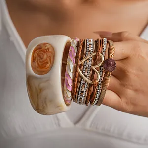 Vista dettagliata del braccialetto in pelle multistrato boho e del cerchio in resina crema