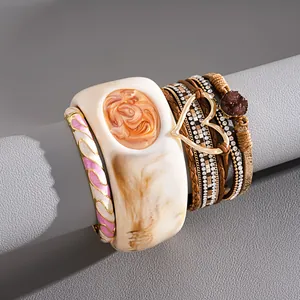 Dettaglio ravvicinato del bracciale vintage in resina e del bracciale in pelle cuore