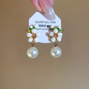 Close-up detail of exquisite enamel flower pearl earrings in French vintage palace style