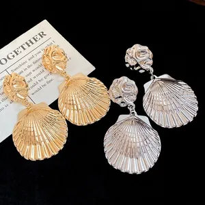 Auffällige Metall-Ohrringe mit zerknitterten Muschel-Anhängern in Gold und Silber