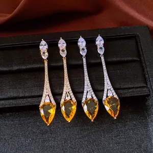 Close-up of elegant vintage teardrop earrings featuring yellow and white cubic zirconia stones.