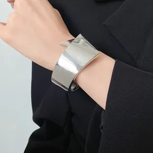 Detailed view of a minimalist silver glossy wide cuff bracelet featuring a geometric design
