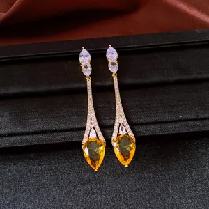 Detailed macro view of vintage 18k gold plated teardrop earrings with yellow zircon