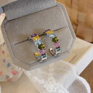 Elegant multi-colored C-shaped hoop earrings featuring oval zircon stones and silver posts
