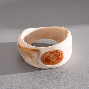Dettaglio di un bracciale vintage in resina crema con intarsio ovale ambrato